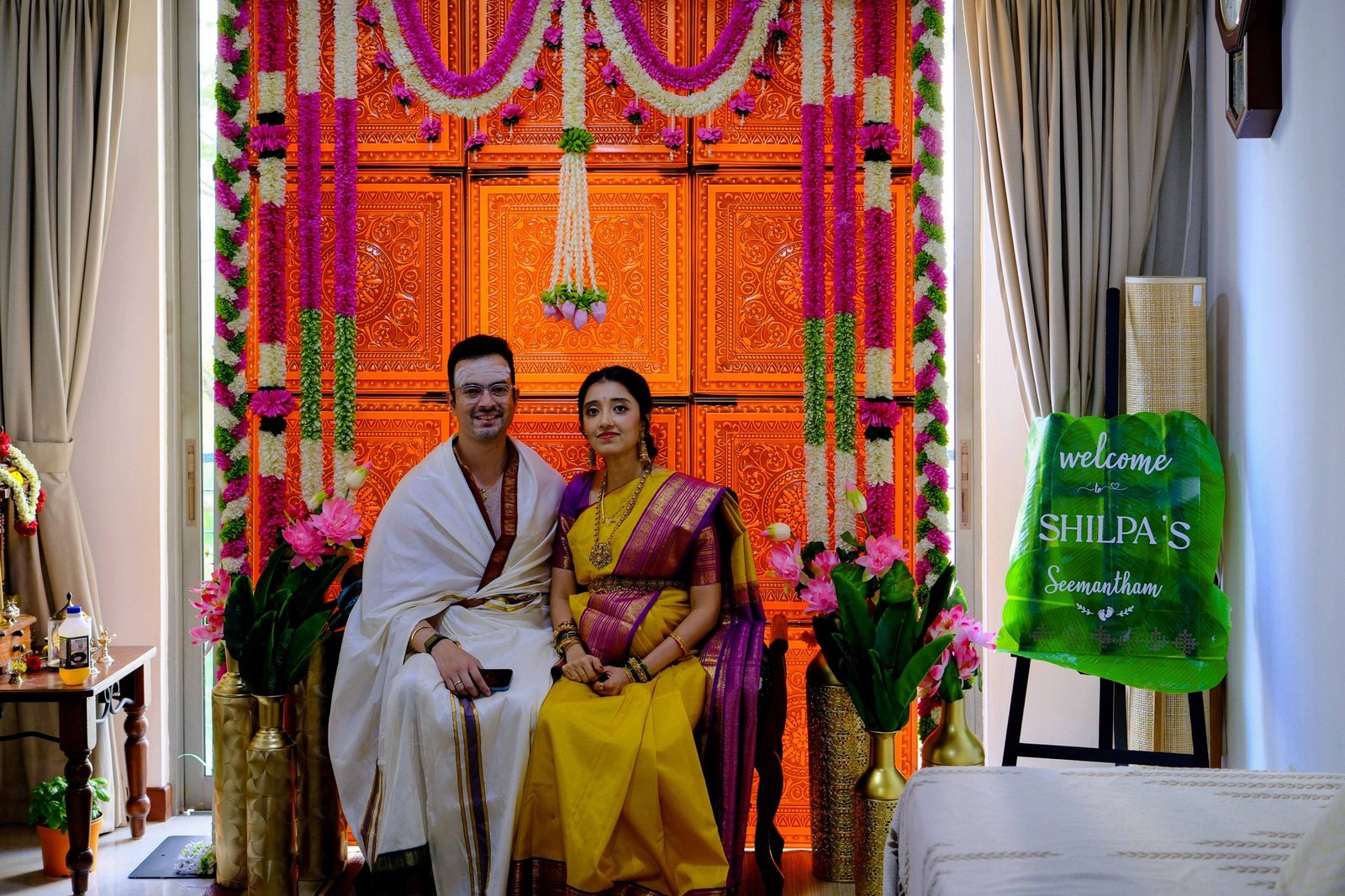 Bride-to-be dressed in a golden silk saree standing by a window