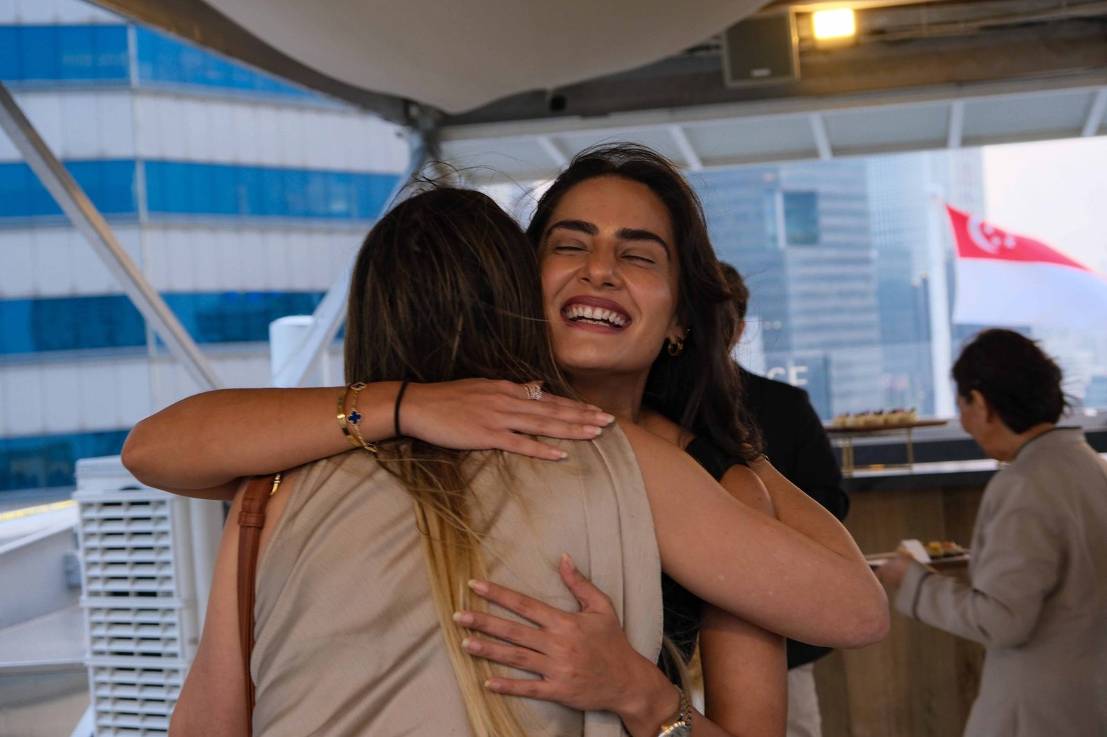 Two women sharing a warm embrace at a reception