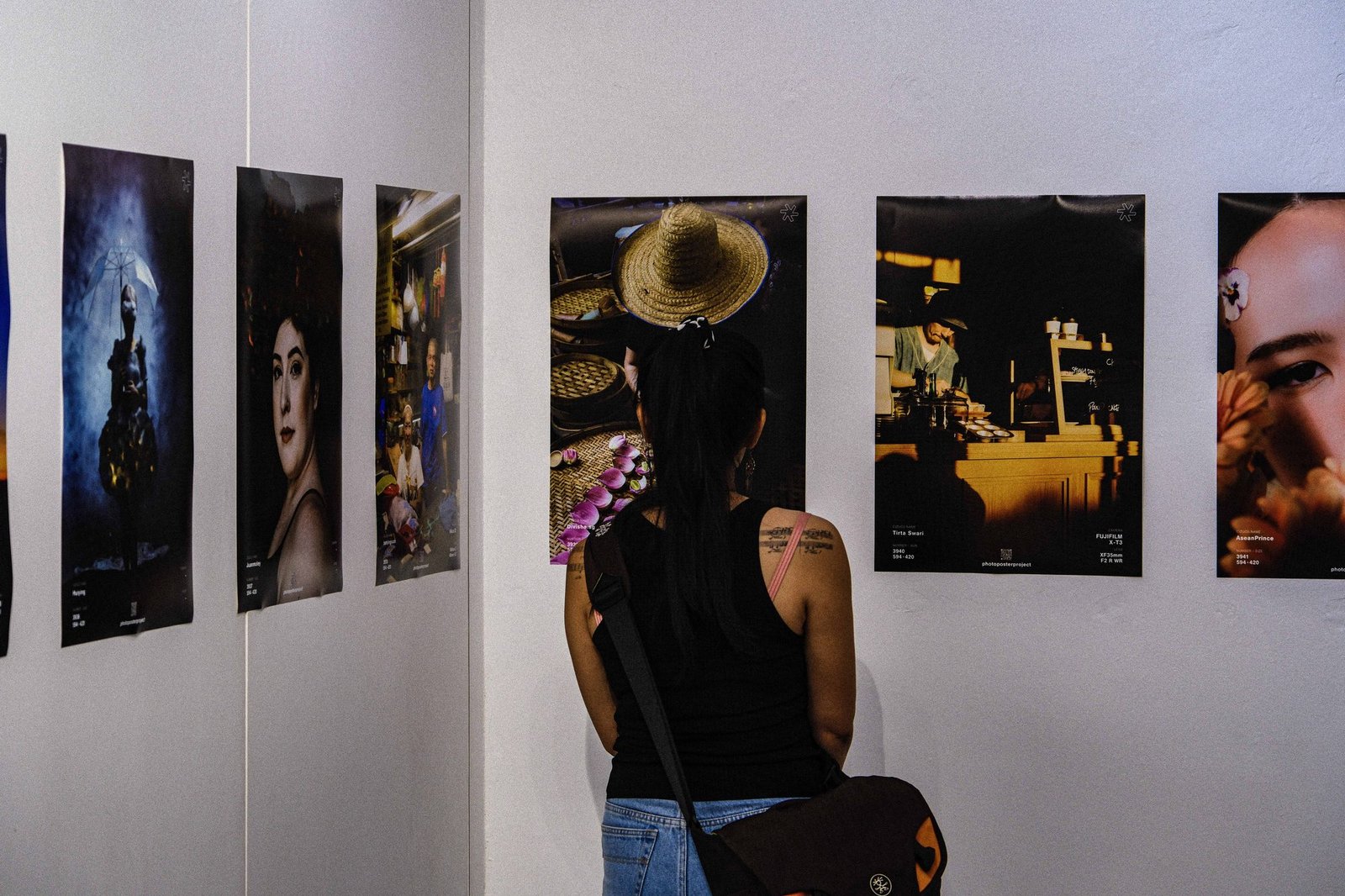 Woman viewing framed photographic prints on a gallery wall