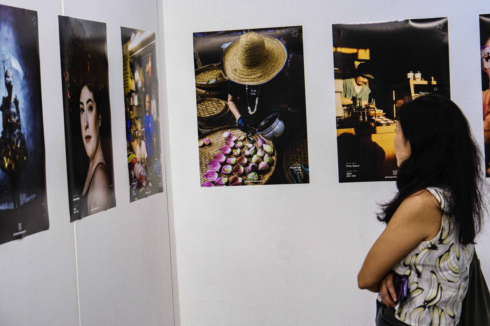 Photographic prints displayed along a gallery corridor at dusk