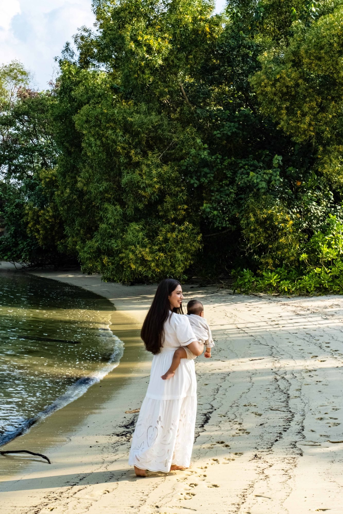 Mother and child walking hand in hand along a sandy path