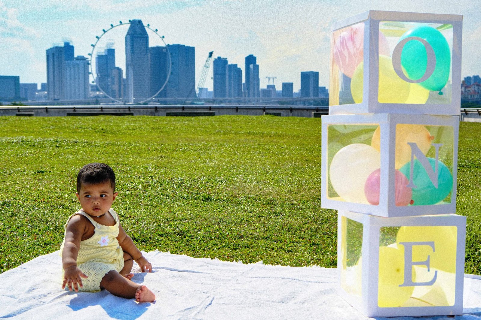 Toddler sitting on a picnic blanket beside alphabet blocks
