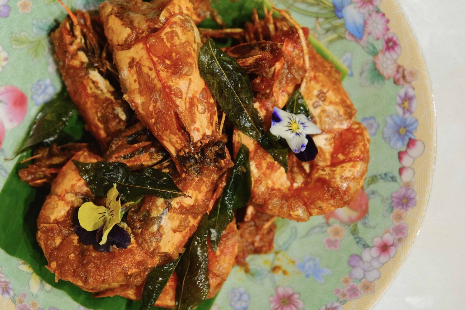 Overhead view of a large chili crab dish garnished with herbs