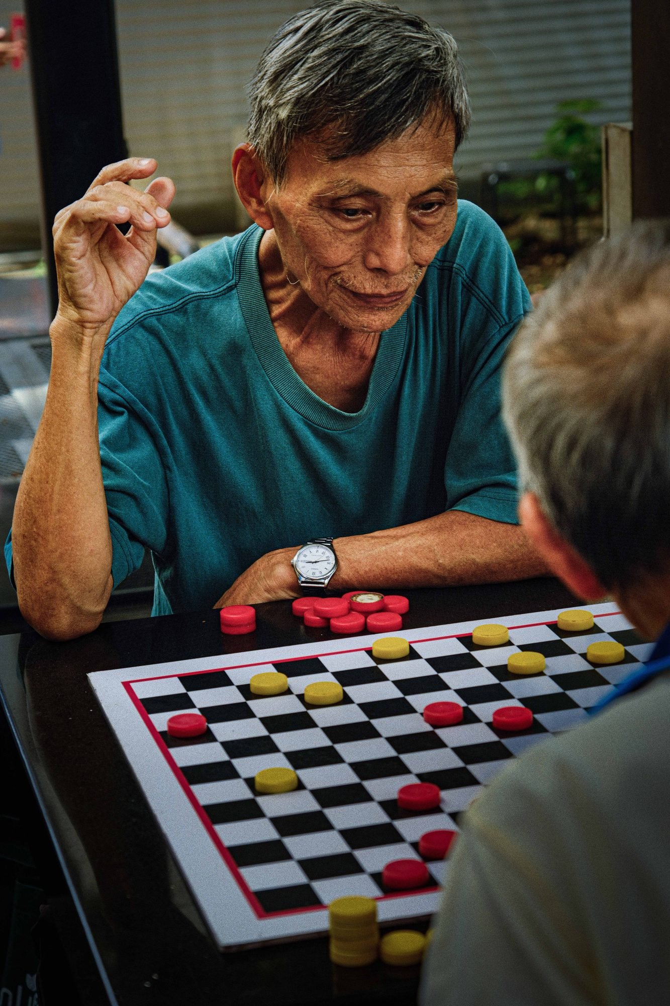 Elderly friends chatting animatedly over a game board