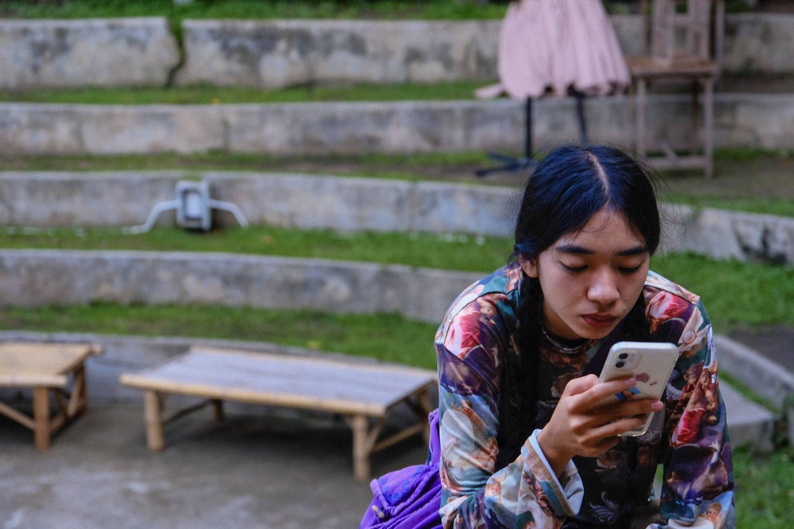Woman checking her phone at a quiet outdoor cafe table