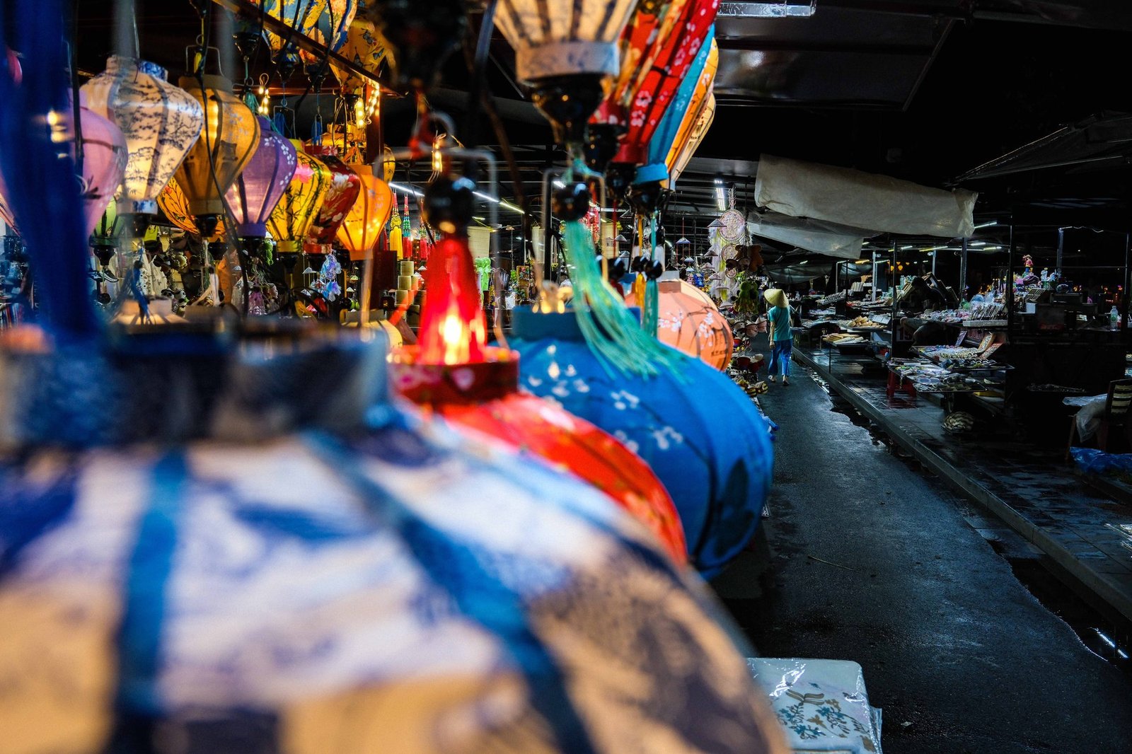 Vendor stalls lit warmly beneath strings of paper lanterns